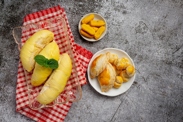 Durian und Snacks auf der dunklen Oberfläche.