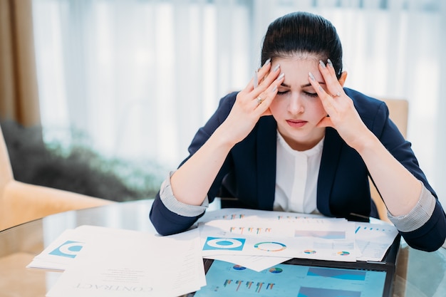 Duro día de trabajo en la oficina. Mujer de negocios cansada en su escritorio