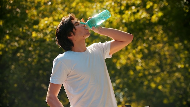 Durstiger junger Mann Trinkwasser nach dem Training