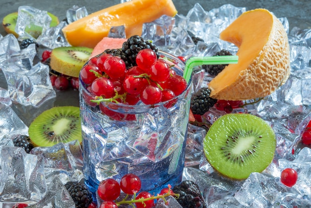 Durstlöschglas mit kaltem Wasser und frischen Sommerfrüchten mit Eis