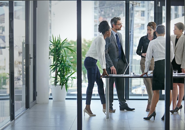 É aqui que nascem os lucros Foto de um grupo de empresários tendo uma discussão séria na sala de reuniões