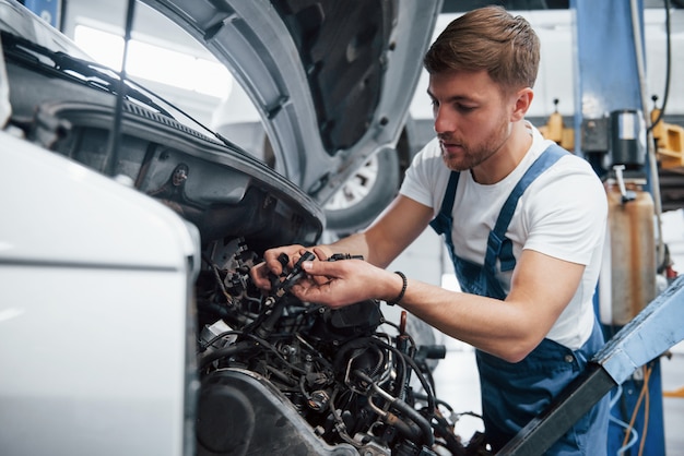 É assim que se parece a sua transmissão. Funcionário com uniforme azul trabalha no salão automóvel