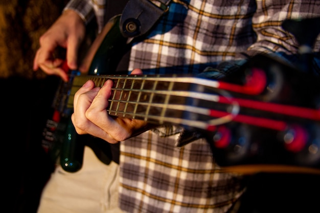 E-Bass-Gitarrist, Nahaufnahmefoto mit weichem selektivem Fokus