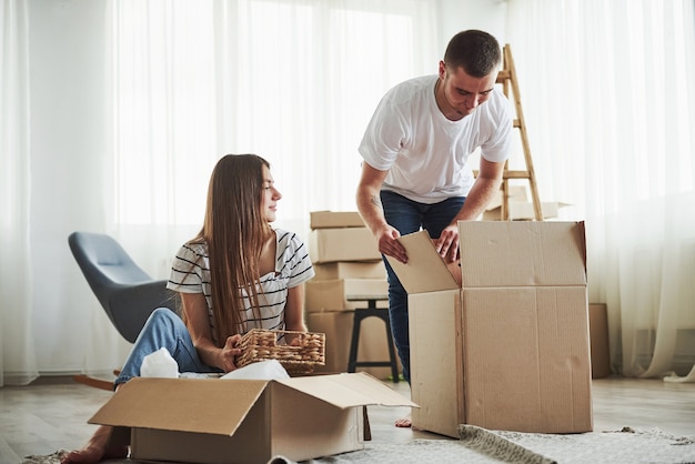 Foto É hora de desempacotar essas caixas. casal jovem alegre em seu novo apartamento. concepção de movimento.