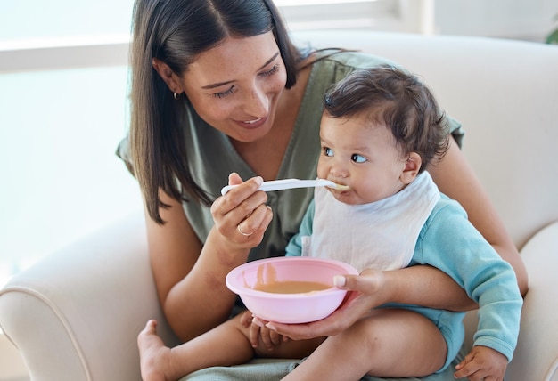 É hora de yum. foto de uma mãe alimentando seu bebê enquanto está sentado em uma cadeira.