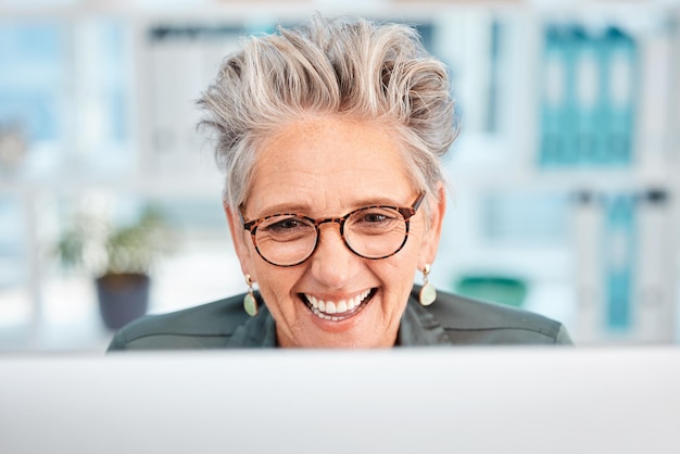 E-mail feliz e mulher de negócios sênior planejando e lendo comunicação em um computador Conexão de web de conversação on-line e rosto de um sorriso de funcionário para site corporativo em um pc