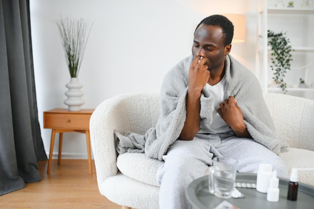 Foto e tratamento de gripe frio doente homem afro-americano usando spray nasal