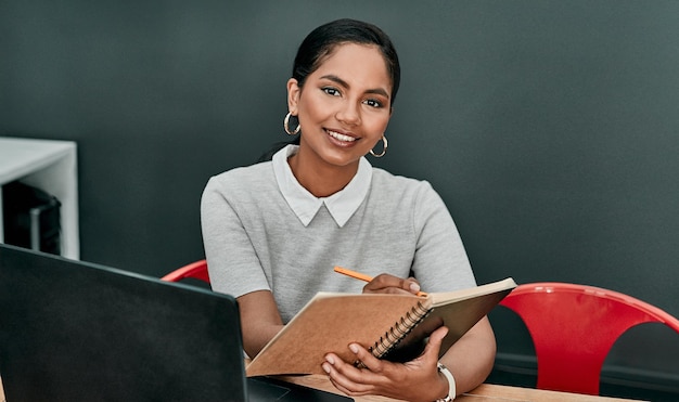 Foto É vital planejar o máximo que puder retrato de uma jovem empresária escrevendo em um caderno enquanto trabalha em um escritório