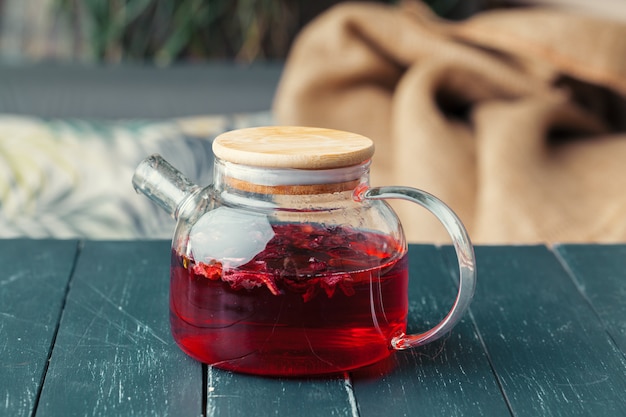 Earl Grey-Tee im Glasteetopf auf hölzernem Plattenabschluß oben