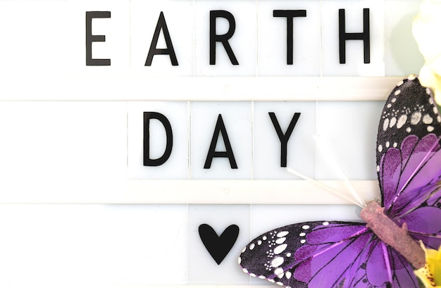 Foto earth day celebration inschrift hintergrund mit schmetterling umweltschutz konzept foto