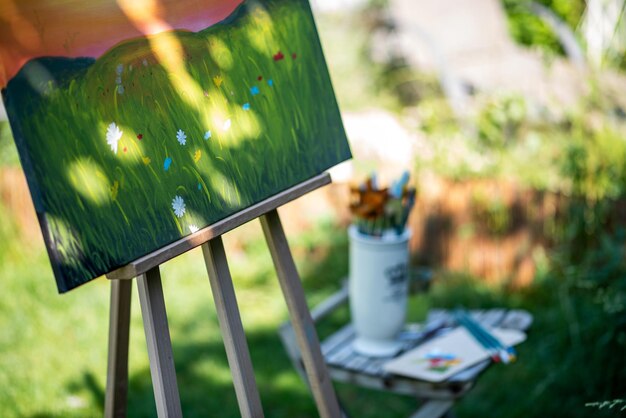 Foto easel com tela de arte pintura ao ar livre em um jardim consciência e conceito de hobbies criativos