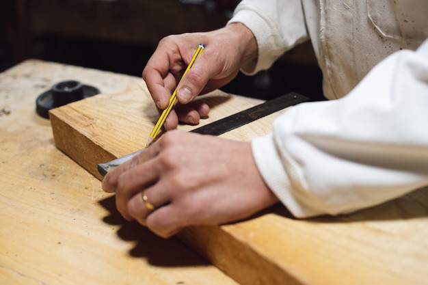 Ebanista midiendo un trozo de madera para marcarlo