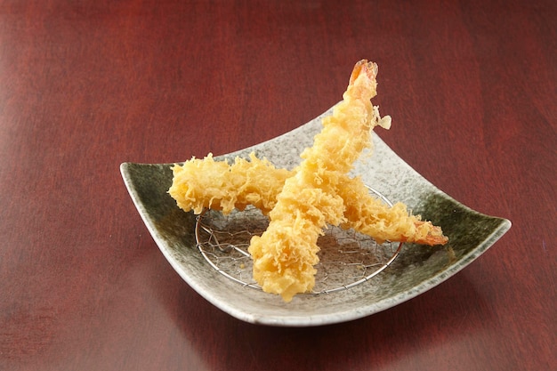 Foto ebi frito servido en un plato aislado en la vista lateral de la mesa de madera de la comida de singapur