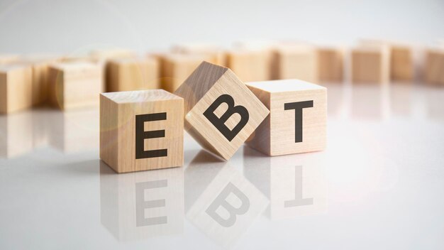 EBT Earnings Before Taxes formulário atirado em bloco de madeira