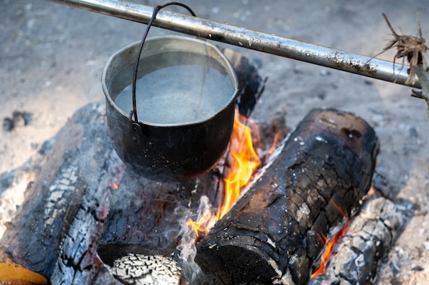 Eche los ingredientes a la sopa que se cuece al fuego en una olla.