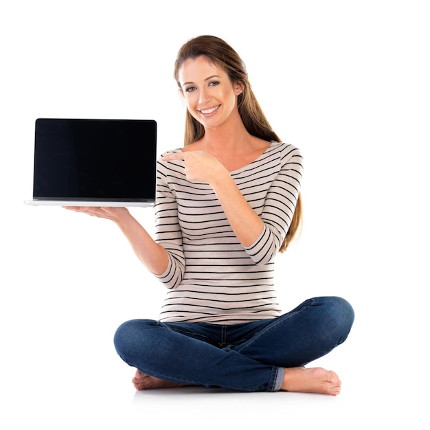 Eche un vistazo aquí Retrato de estudio de una mujer joven que usa una computadora portátil contra un fondo blanco