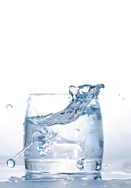 Echó un cubo de hielo al vaso de agua.