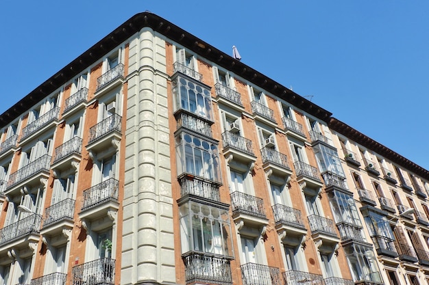 Ecke der alten klassischen Gebäude mit eleganten Fenstern und Balkonen im zentralen Bezirk Madrid