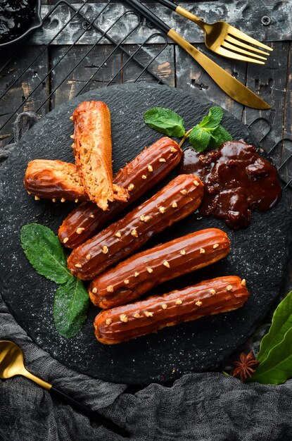 Eclair com creme de caramelo Sobremesa de caramelo e nozes em uma placa de pedra preta Vista superior Estilo rústico