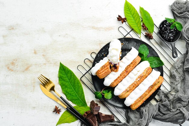 Eclair com creme Sobremesa cremosa em uma placa de pedra preta Vista superior Estilo rústico