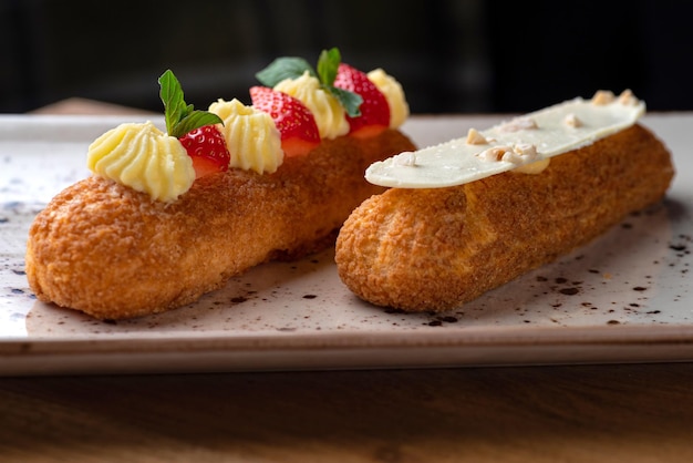 Eclair hecho con crema y avellana en plato sobre una mesa de madera Comida saludable