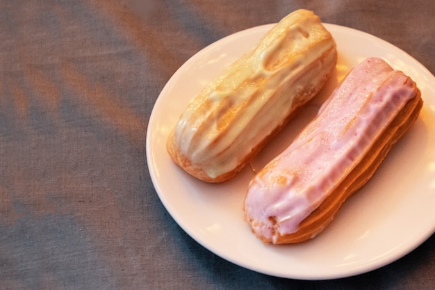 Eclair de pistacho y zarzamora en un plato de cerámica blanca