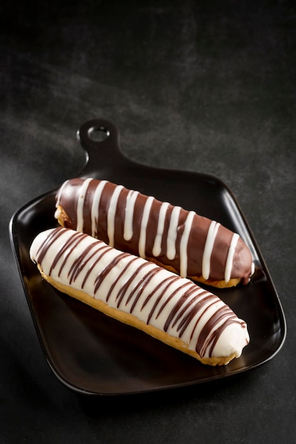 Eclair Sabroso pastel de chocolate en la mesa