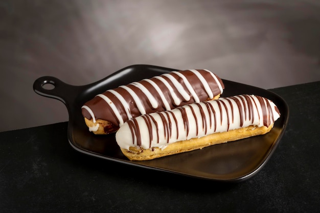 Eclair Sabroso pastel de chocolate en la mesa