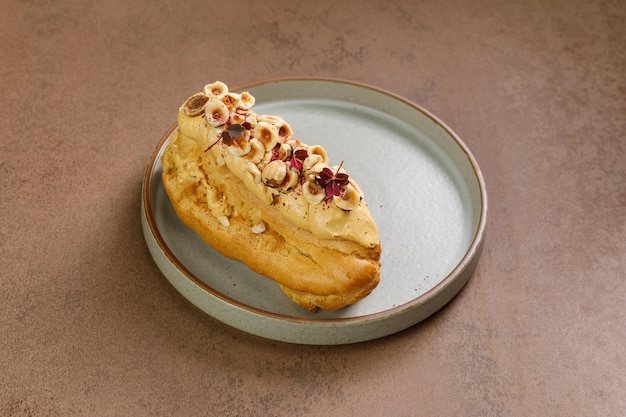 Eclair serviert mit frittierten Haselnüssen