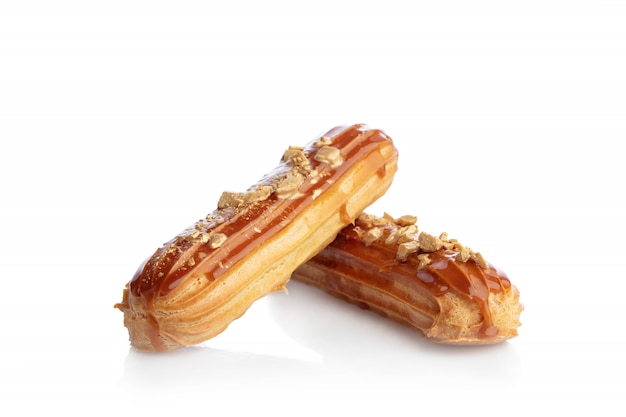 Eclairs de caramelo rociados con oro aislado en blanco