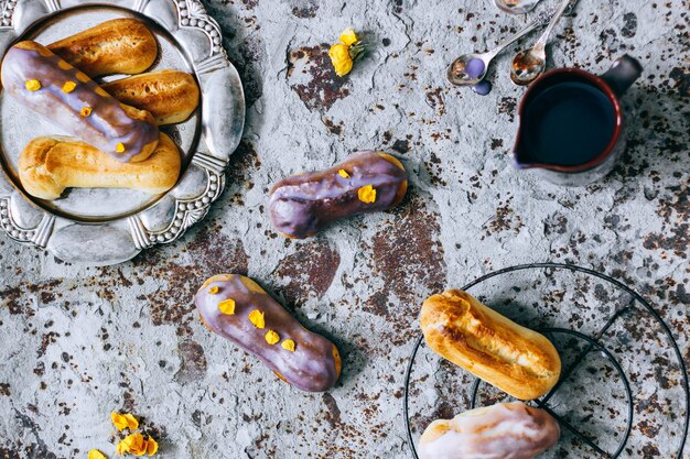 Eclairs caseiros em esmalte colorido sobre um fundo de concreto de metal