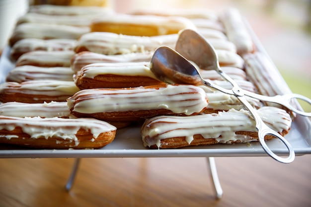 Eclairs de chocolate blanco vertidos en catering