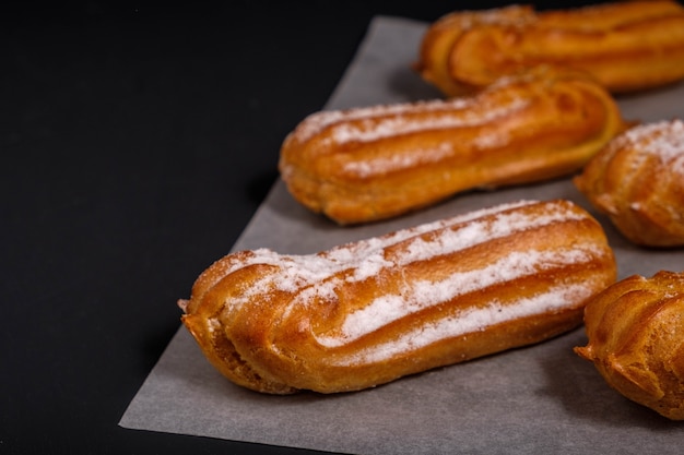 Eclairs con crema sobre un fondo oscuro