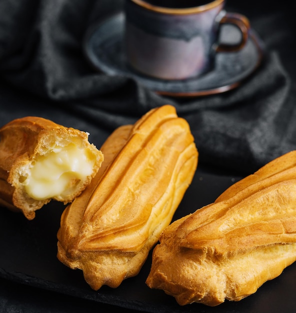 Eclairs con crema en tablero de piedra