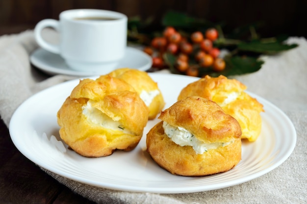 Éclairs de pãezinhos recém-assados recheados com queijo cottage picante e uma xícara de café