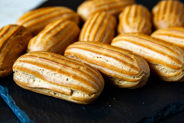 Eclairs franceses tradicionales con chocolate. Postre sabroso