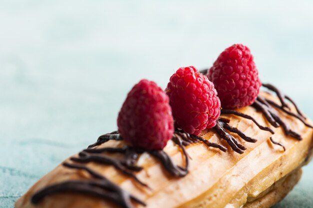 Eclairs mit Erdnüssen, Schokoladenglasur und Himbeeren