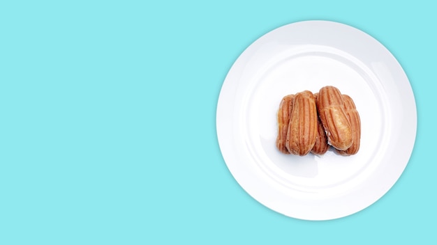 Eclairs con natillas en un plato blanco sobre un fondo aislado con un lugar para copiar el texto