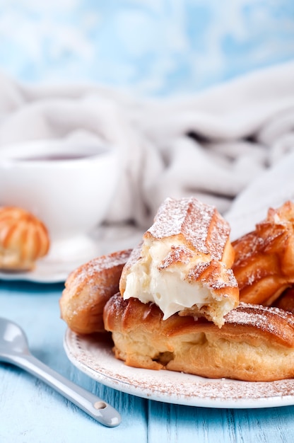 Eclairs saborosos na mesa de madeira