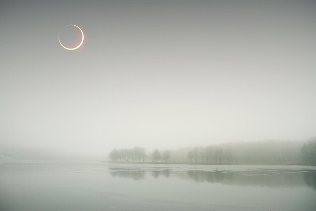 Eclipse de sol en la niebla de otoño