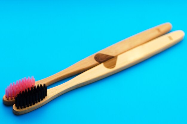 Foto eco cepillos de dientes de bambú natural sobre fondo azul. cero desperdicios planos.