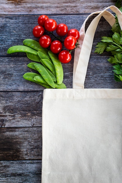 Eco Shopping Bag com legumes orgânicos frescos e salada em fundo de madeira Flat Lay