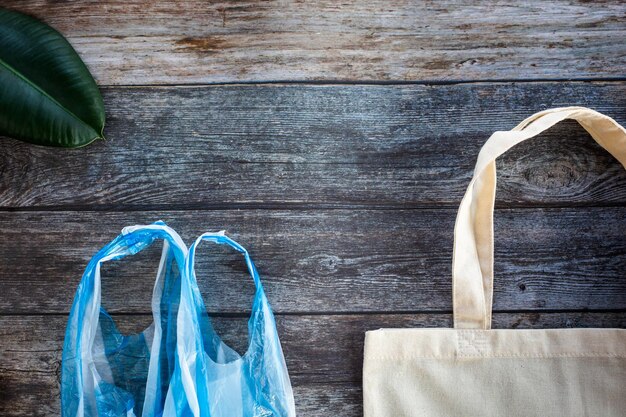 Eco Shopping Bag gegen eine Plastiktüte auf Holzhintergrund Flat Lay Save Planet Earth