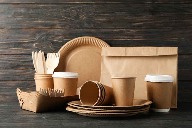 Eco - vajilla y bolsa de papel amigables en la mesa de madera, espacio de copia