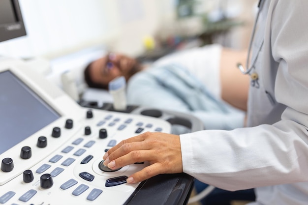 Foto ecografista hábil que usa una máquina de ultrasonido en el trabajo hombre que visita a su médico para un examen de ultrasonido médico ecografista profesional que realiza ultrasonido en una clínica moderna