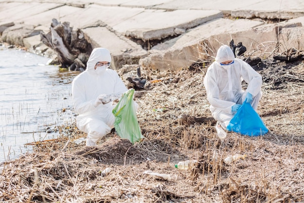 Ecologistas trabalhando juntos na limpeza de lixo na margem do lago