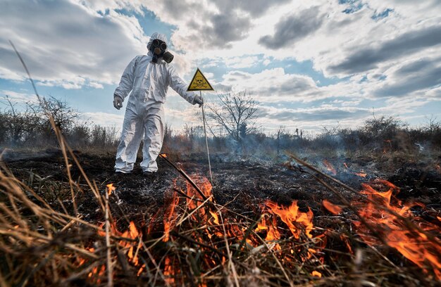 Foto ecólogo bombero con máscara de gas trabajando en el campo con incendios forestales