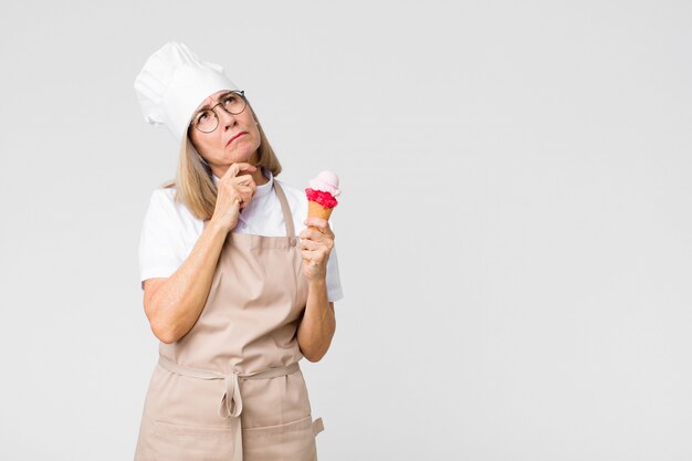 Edad media bonita mujer panadero con un helado