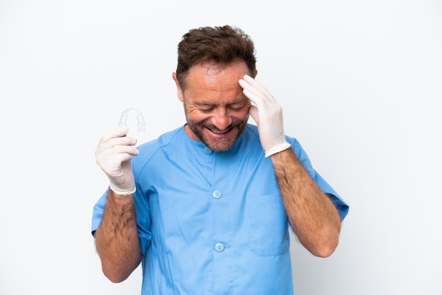 Edad media dentista hombre sujetando previendo aislado sobre fondo blanco riendo