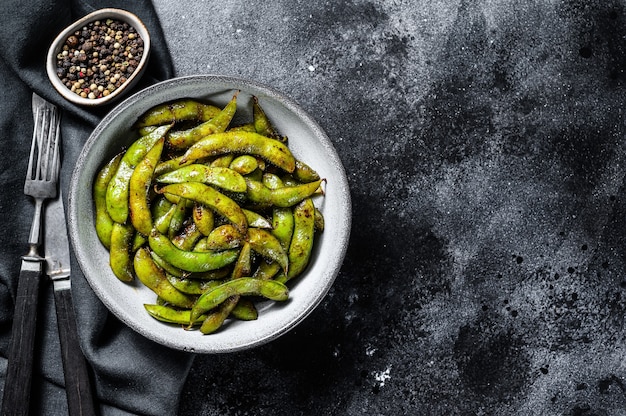 Edamame al vapor, soja verde en una sartén, cocina del este de Asia. Fondo blanco.